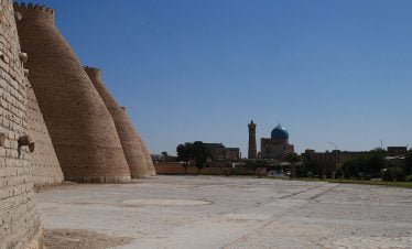 Usbekistan - Buchara, Sehenswürdigkeiten in Buchara, die Altstadt Buchara, Die gewaltigen Festungsmauern der Ark von Buchara mit Blick auf die Kalon-Moschee während der Usbekistan Zeitreise, Blick auf die massiven Mauern der Zitadelle Ark in Buchara während der Usbekistan Rundreise durch Kultur und Natur.