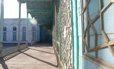 Kunstvolle Holzschnitzereien und verzierte Säulengänge in einem traditionellen usbekischen Palast während der Usbekistan Zeitreise, Der prachtvolle, blau verzierte Innenhof des Sommerpalasts Sitorai Mohi Xosa in Buchara auf der Usbekistan Rundreise,