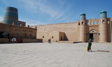 Chiwa - Usbekistan, Usbekistan im Aufbruch, Das prächtige Westtor Ata-Darvaza mit den türkisfarbenen Kuppeln und dem Kalta Minor Minarett in Chiwa während der Usbekistan Zeitreise, Das historische Westtor Ata-Darvaza in Chiwa, ein markanter Orientierungspunkt auf der Usbekistan Rundreise,
