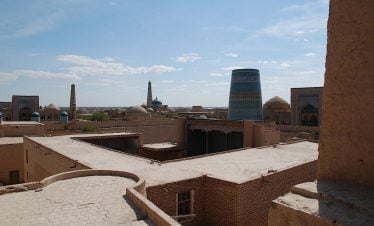 Usbekistan - Chiwa, Blick über die historischen Lehmbauten und das markante blaue Minarett Kalta Minor in der Altstadt von Chiwa während der Usbekistan Zeitreise, Blick über die Dächer der Altstadt Ichan Qala in Chiwa während der Usbekistan Rundreise,