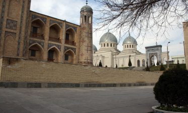 Usbekistan - Tashkent, Die historische Kukeldasch-Madrasa neben den weißen Kuppeln der Dschuma-Moschee in Taschkent während der Usbekistan Zeitreise,